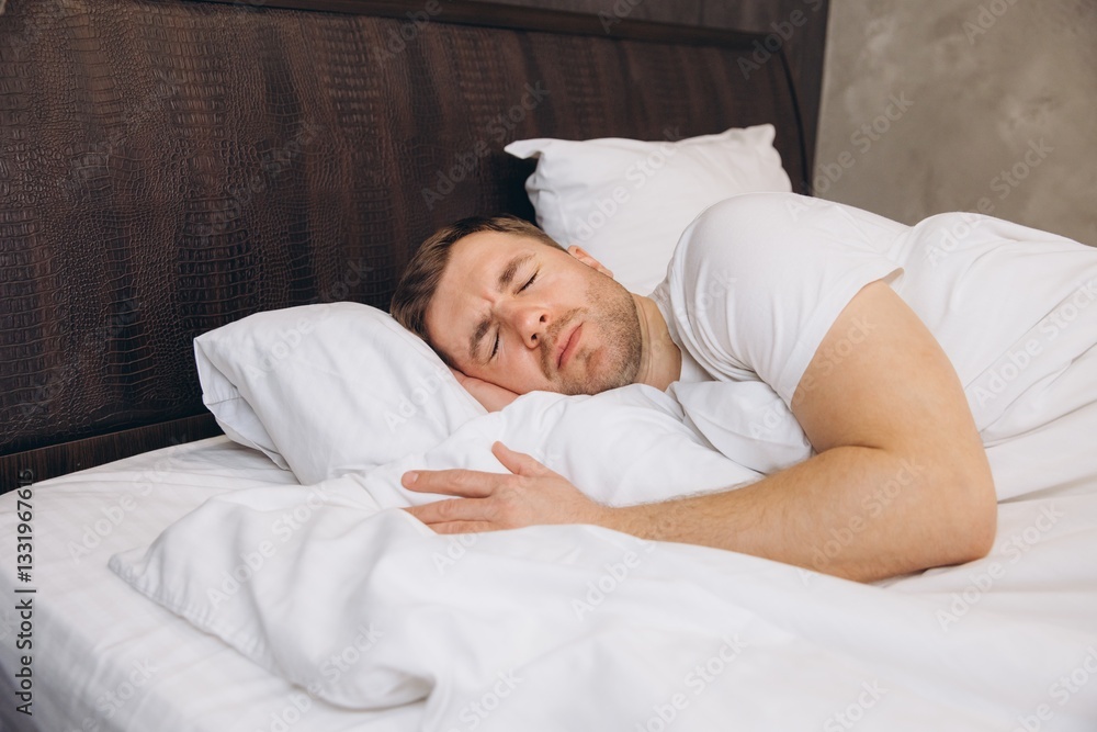 Man sleeping peacefully in bed hugging pillow Man sleeping peacefully in bed hugging pillow