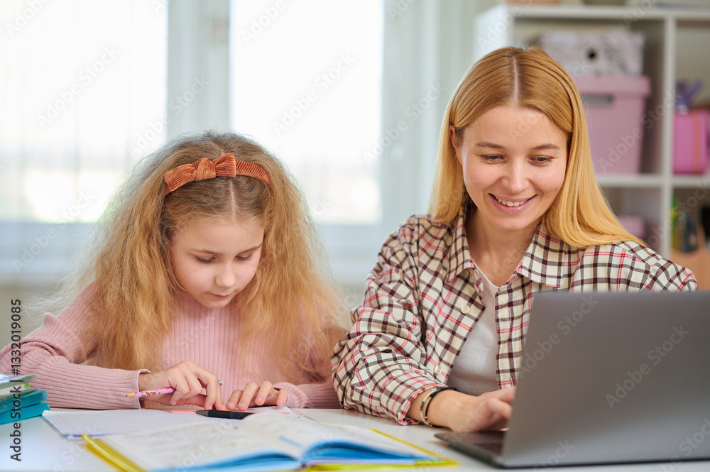 Mother glances at daughter's homework while typing on laptop, balancing work and parenting. Harmonious family study time, shared home learning space Mother glances at daughter's homework while typing on laptop, balancing work and parenting. Harmonious family study time, shared home learning space