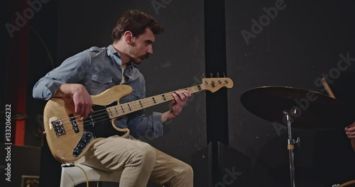 A jazz trio practices for their upcoming concert in a dimly lit studio. The bassist plays with focus and passion, while the drummer keeps the rhythm steady.