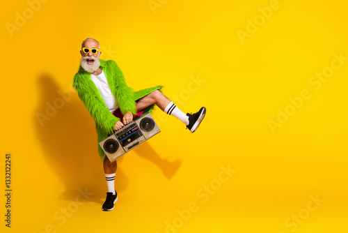 Bild auf Leinwand Eccentric mature man dancing with boombox and vibrant outfit
