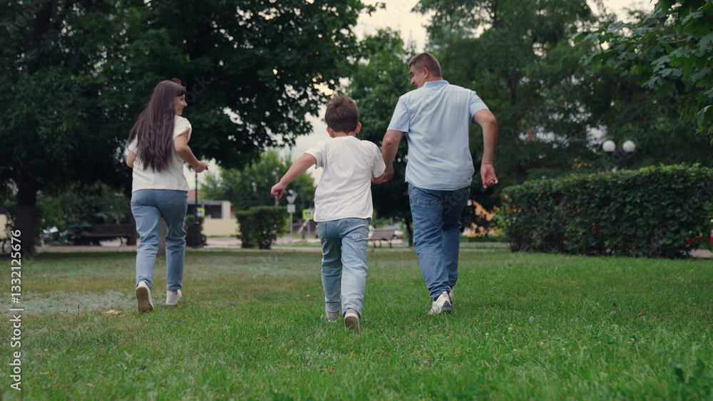 Obraz premium happy family, boy laughing holding father mother by hand, child father mother running in summer park, family trip, child play, family run, boy son running with parents park, group people running feet