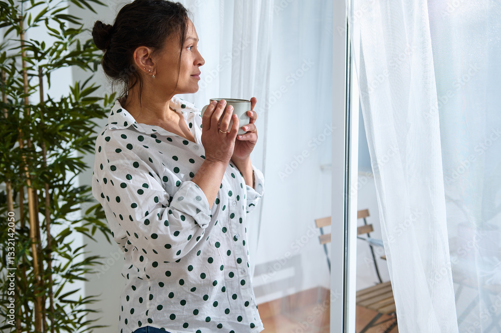 Woman Enjoying Beverage in Cozy Home While Contemplating at the Window Woman Enjoying Beverage in Cozy Home While Contemplating at the Window