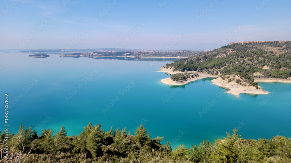 Obraz premium On a sunny spring day, Seyhan Lake glistens with its clean, turquoise waters, creating a serene and inviting atmosphere reminiscent of a picturesque paradise