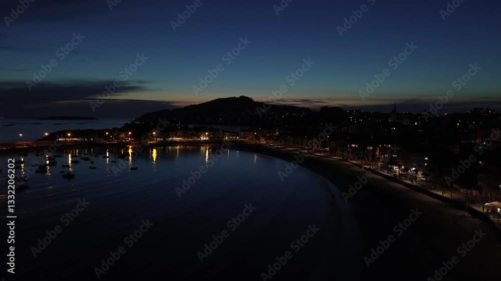 Ascent over Panxón Beach during the blue hour, revealing the promenade lined with palm trees, the harbor with boats, Monteferro’s illuminated houses, and the Estelas and Cíes Islands on the horizon. Ascent over Panxón Beach during the blue hour, revealing the promenade lined with palm trees, the harbor with boats, Monteferro’s illuminated houses, and the Estelas and Cíes Islands on the horizon.