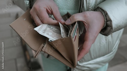 Side view of Caucasian man hands holding beige wallet with zloty money. Hands with purse full of two hundred zloty bills, close-up