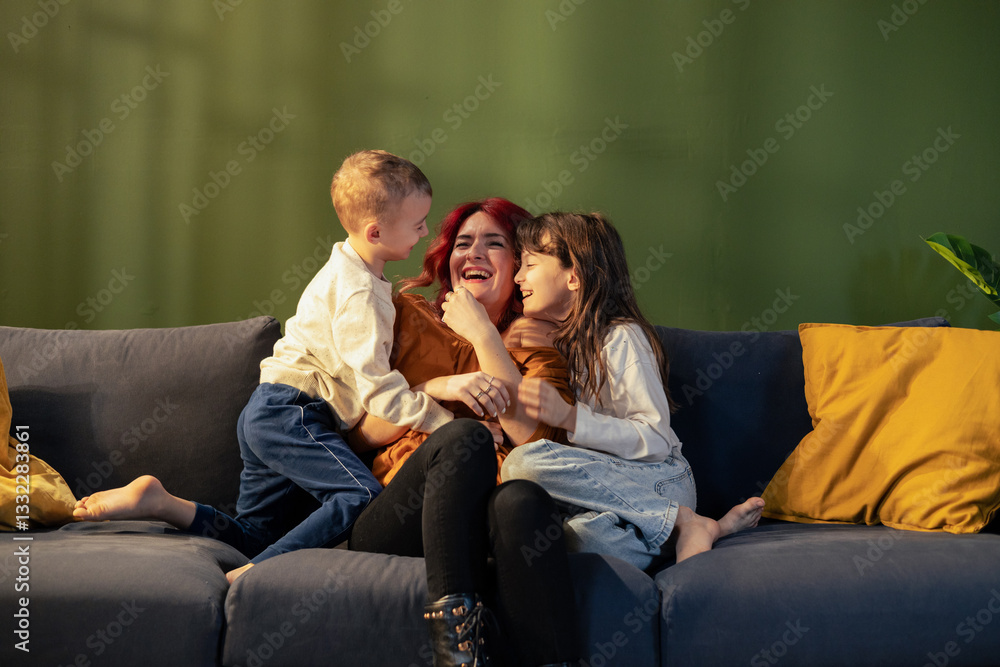 Mother having fun with daughter and son on sofa Mother having fun with daughter and son on sofa
