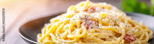close up of creamy Italian carbonara pasta garnished with grated cheese and black pepper