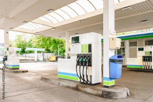 Fuel dispensers at a modern gas station with canopies during daylight in a suburban area