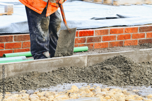 Construction workers laying edging kerb on concrete