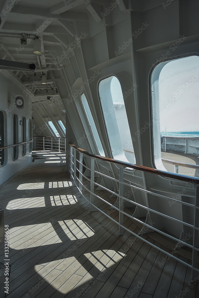 Outdoor promenade teak boat deck patio terrace onboard legendary ocean liner cruiseship cruise ship with close up of railing, deck chairs and life buoy