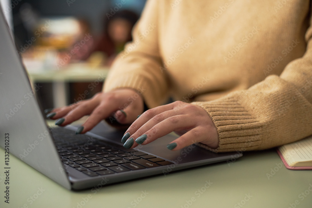 Close-up of businesswoman typing on laptop and working online at her workplace in office Close-up of businesswoman typing on laptop and working online at her workplace in office