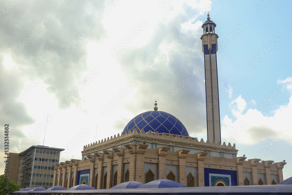 Majestic mosque with blue dome standing against cloudy sky in Abidjan Ivory Coast