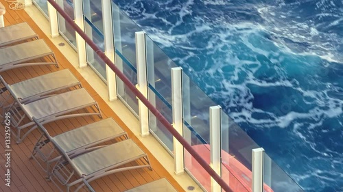 Sun loungers on cruise ship deck at sunset with waves passing by
