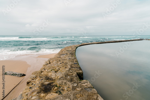 The natural pool of Azenhas do Mar blends seamlessly with the Atlantic ocean in Portugal.
