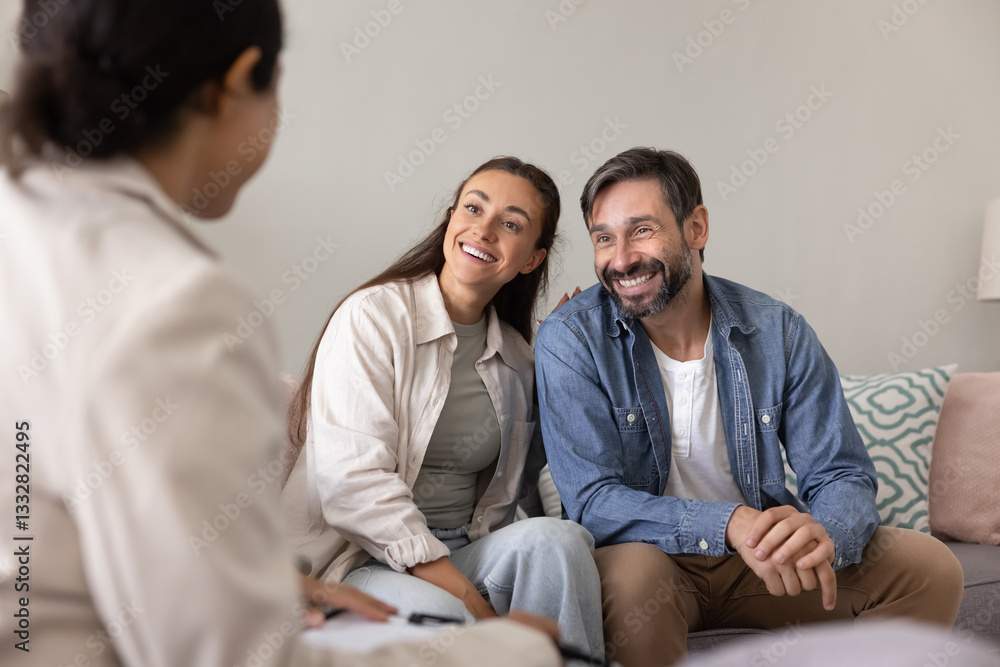 Cheerful married couple meeting with medical insurance agent, female professional, consultant at home, talking to advisor, smiling, laughing, discussing agreement terms Cheerful married couple meeting with medical insurance agent, female professional, consultant at home, talking to advisor, smiling, laughing, discussing agreement terms