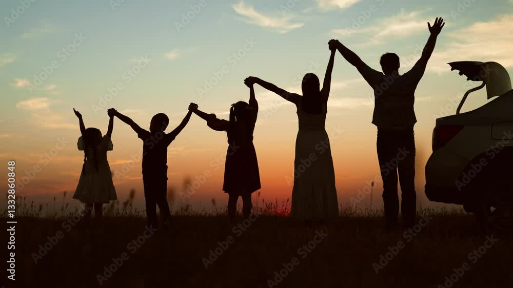 Big family at sunset holding hands, silhouettes. Happy people children parents lined up according to height held hands raised in air with joyful cheerful feeling of freedom anticipation of journey. Big family at sunset holding hands, silhouettes. Happy people children parents lined up according to height held hands raised in air with joyful cheerful feeling of freedom anticipation of journey.