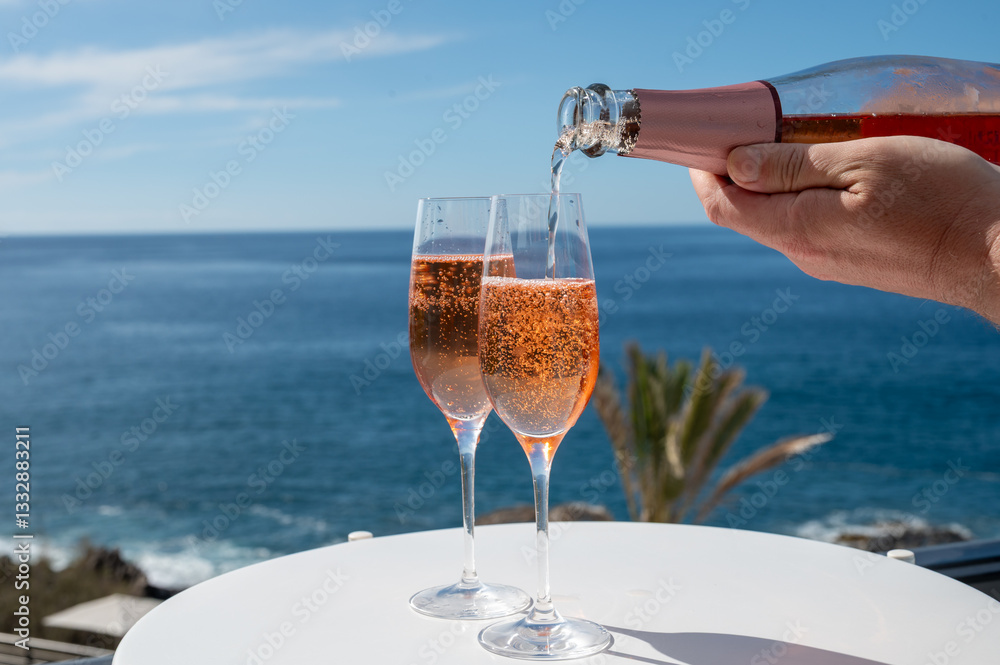Obraz premium Celebration, birthday party, drinking of rose cava or champagne sparkling wine in vacation resort Costa Adeje, Tenerife, Canary islands winter sun vacation, Spain