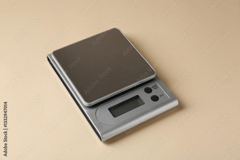 Modern electronic kitchen scale on beige background, closeup Modern electronic kitchen scale on beige background, closeup