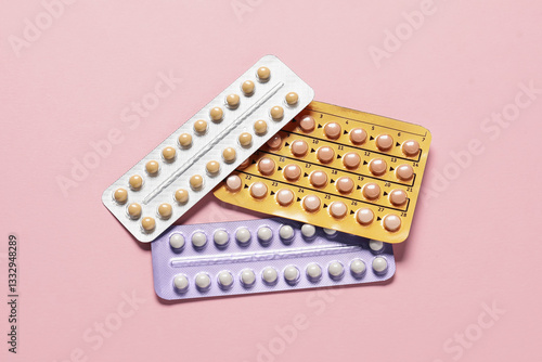 Foto Blisters of oral contraceptive pills on pink background, flat lay