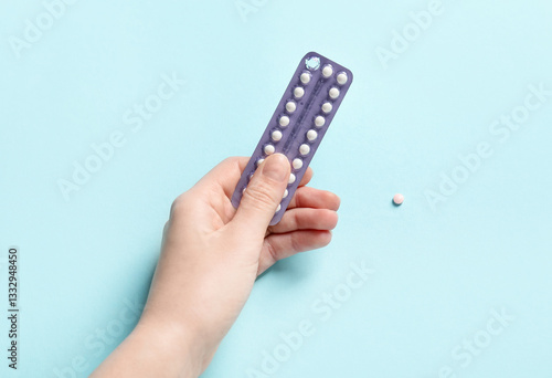 Wallpaper Mural Woman holding blister of contraceptive pills on light blue background, closeup Torontodigital.ca