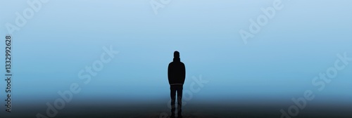 Obraz na płótnie A lone figure stands in the distance, shrouded in misty ambiance, representing isolation, contemplation, and introspection in a serene yet haunting environment. w salonie