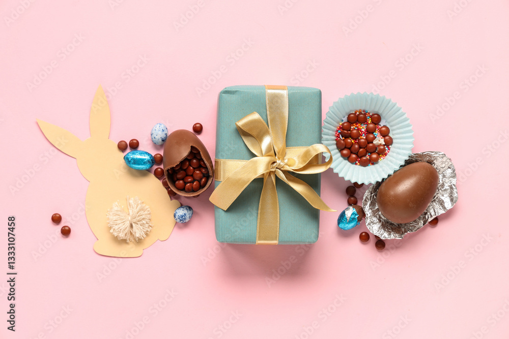Sweet chocolate Easter eggs with candies, gift box and bunny made of paper on pink background Sweet chocolate Easter eggs with candies, gift box and bunny made of paper on pink background