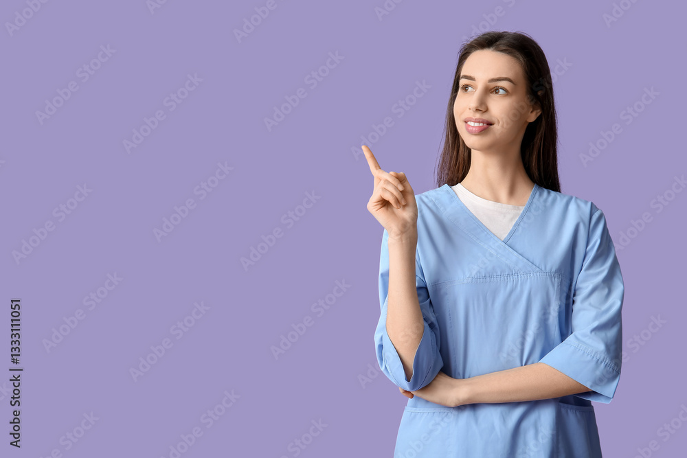 Young female doctor pointing at something on lilac background Young female doctor pointing at something on lilac background
