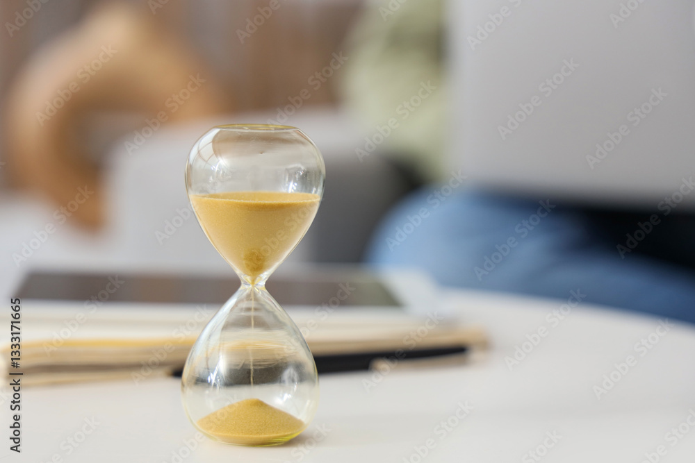 Hourglass on table in room, closeup Hourglass on table in room, closeup