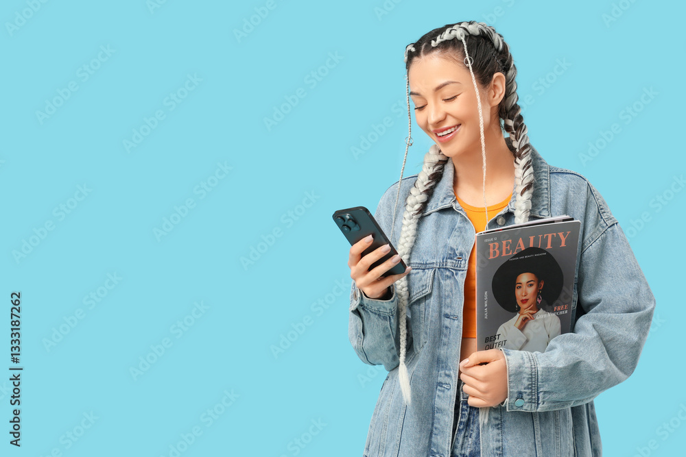 Beautiful young stylish happy woman with magazine and mobile phone on blue background Beautiful young stylish happy woman with magazine and mobile phone on blue background