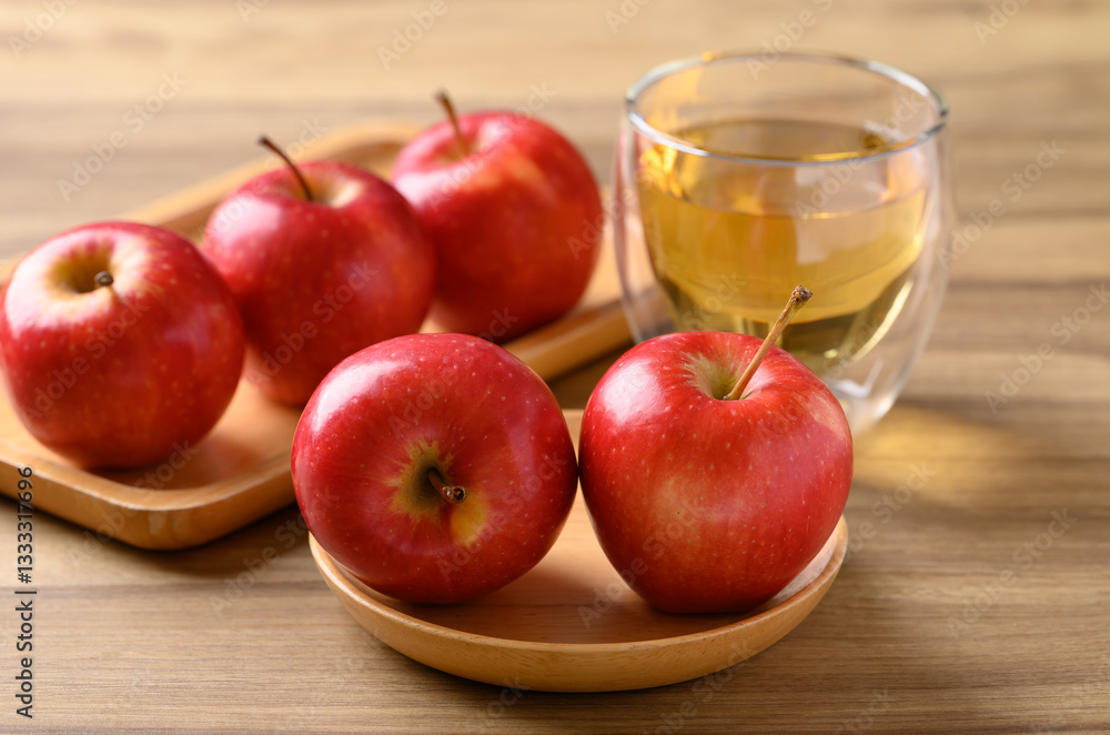 Red apple fruit and apple cider in glass on wooden background Red apple fruit and apple cider in glass on wooden background
