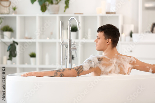 Handsome man taking bath wi...