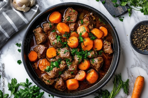 Beef stew with carrots in pan, overhead view