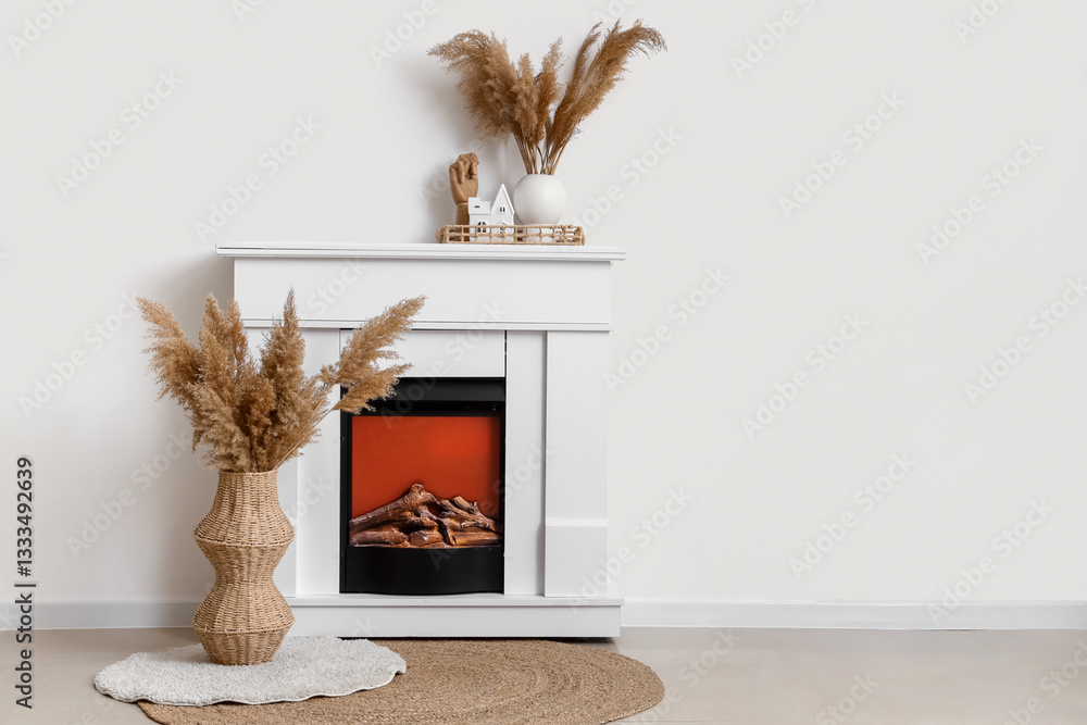 Fototapeta premium Fireplace and pampas grass in vases near white wall in room
