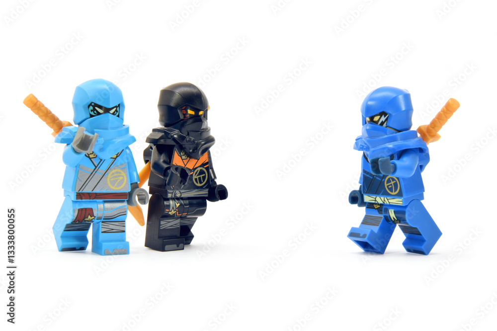 Fototapeta premium Editorial illustrative image of lego ninjago minifigures black ninja Cole, water ninja Nia and Jay isolated on white.