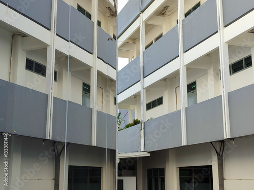 Canvas Print White grey multistorey building reflected on the glass windows of the building b