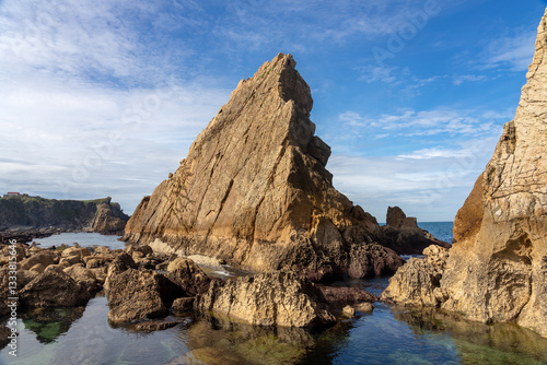 Arnia beach rock formations in the Costa Quebrada geological park in Cantabria, Spain, at sunset with the rock formations.