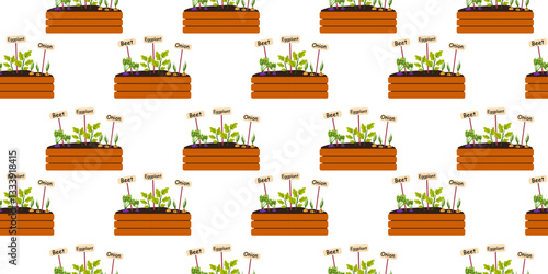 Colorful vegetable garden bed with labels showing various plants growing in spring sunlight