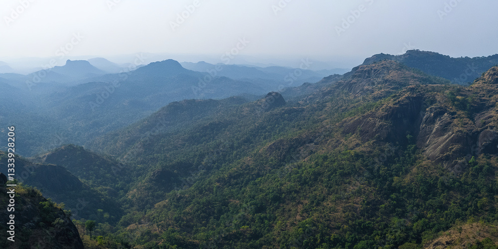 Fototapeta premium Mountainous landscape with lush greenery and distant peaks
