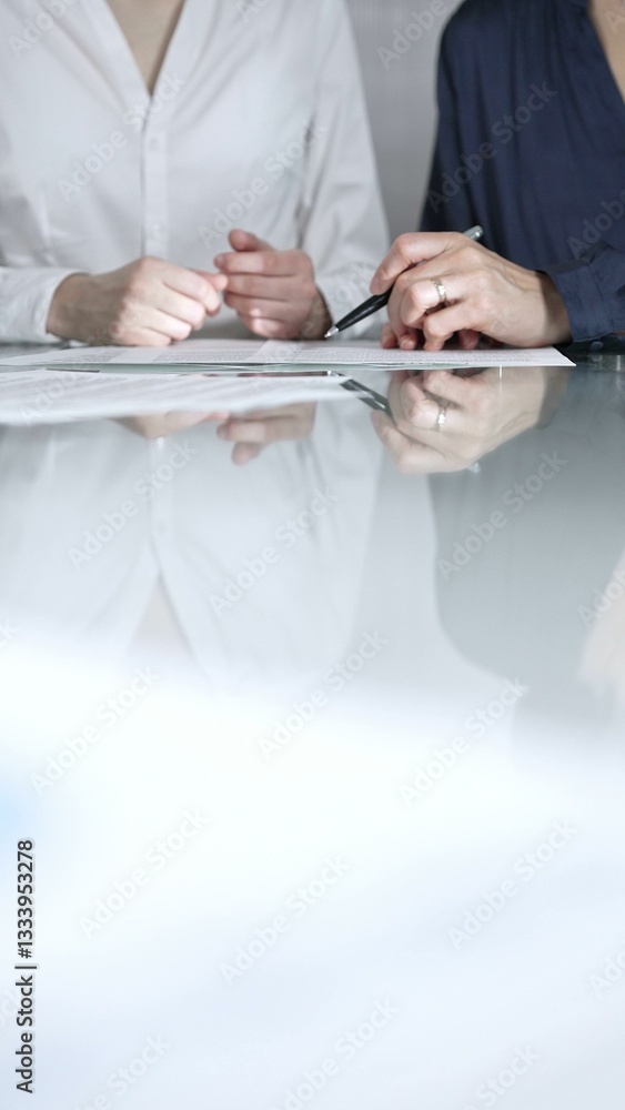 Business people are reviewing contract terms during a meeting, negotiating and making decisions together, vertical close up view. Copy space area