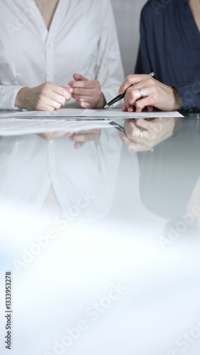 Obraz na płótnie Business people are reviewing contract terms during a meeting, negotiating and making decisions together, vertical close up view. Copy space area w salonie