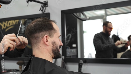 Obraz na płótnie Skilled barber trimming client's hair using professional scissors, creating contemporary hairstyle in modern barbershop setting with precise, professional technique. w salonie