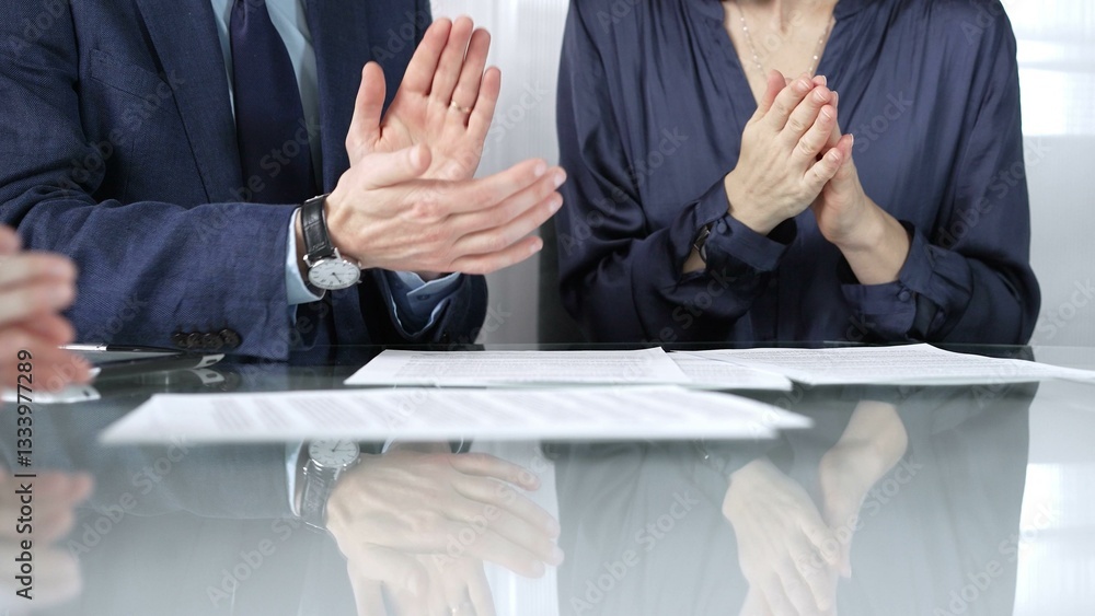 Unrecognizable business professionals applauding and celebrating achievements at glass table after successful meeting and contract signing. Business people concept, close up view