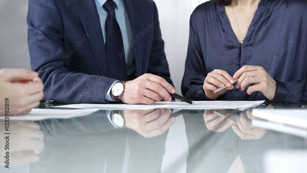 Business people reviewing contract terms during a meeting, negotiating and making decisions together. Business people concept, close up