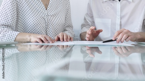 Obraz na płótnie Business colleagues reviewing a contract, engaging in negotiations and strategic decision making in a professional office setting, white casual dress style. Business people concept w salonie
