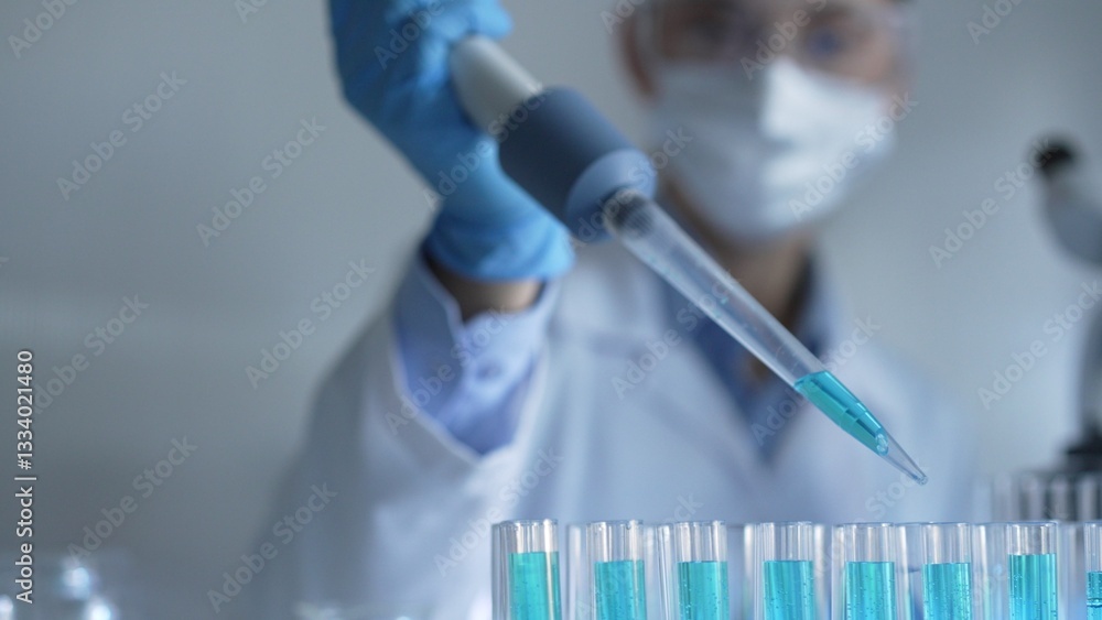 Woman scientist researcher using a micropipette to fill up test tubes with a blue liquid in laboratory setting, closeup view. Medicine and science concept