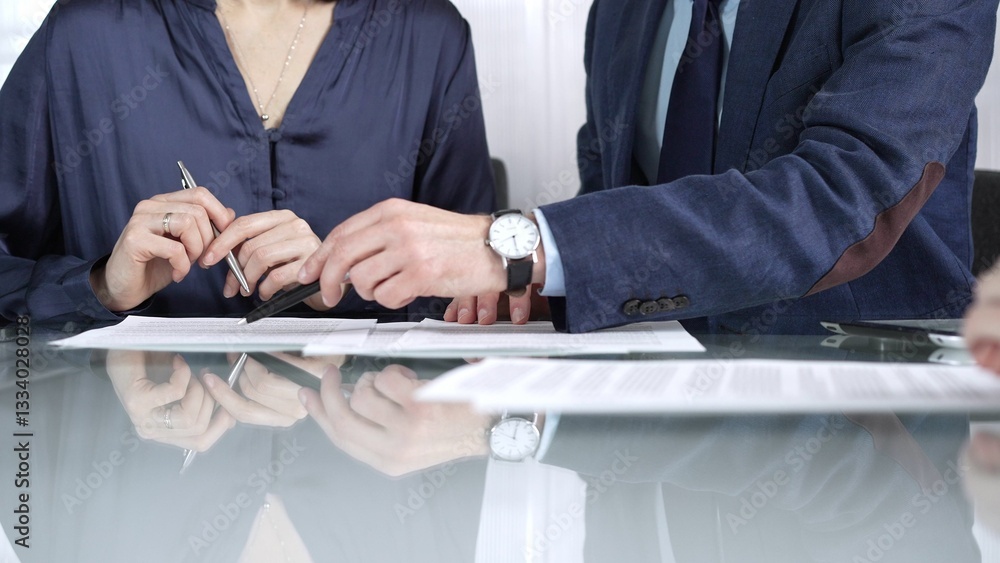 Business people reviewing contract terms during a meeting, negotiating and making decisions together. Business people concept, close up