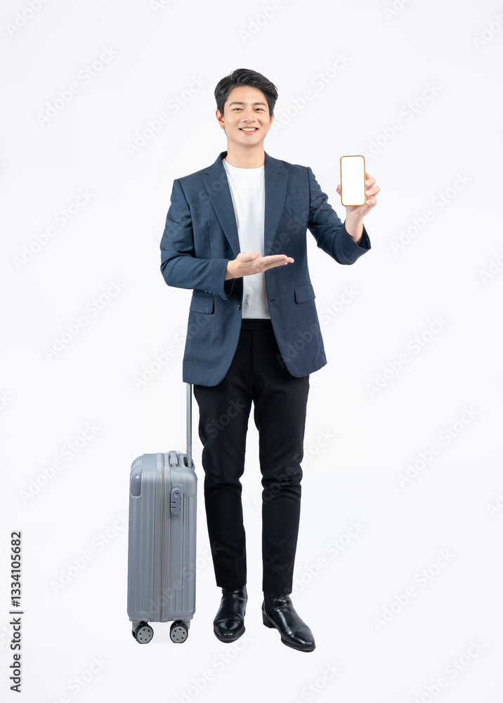 Full body image of young asian businessman pulling suitcase and using phone on white background Full body image of young asian businessman pulling suitcase and using phone on white background