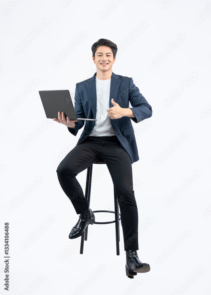 Full body image of young Asian business man using laptop and sitting in chair on white background Full body image of young Asian business man using laptop and sitting in chair on white background