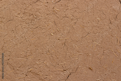Textured background of wall of clay with straw. Adobe wall. Clay and straw are popular building materials in Central Asia