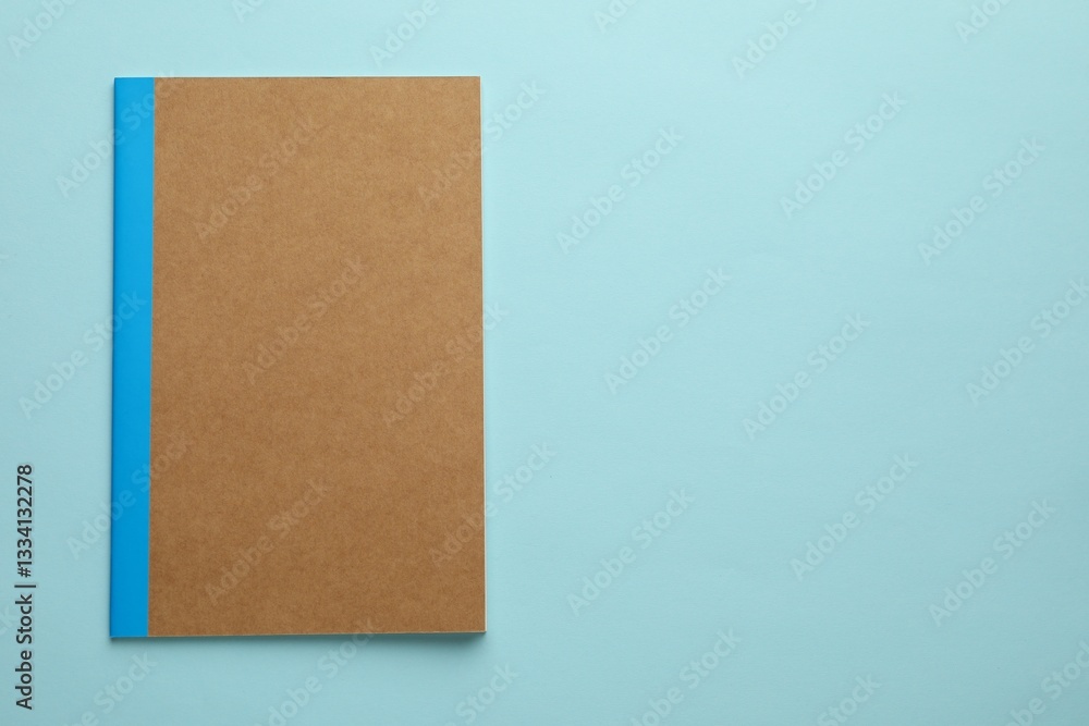 One copybook on light blue background, top view. Space for text One copybook on light blue background, top view. Space for text